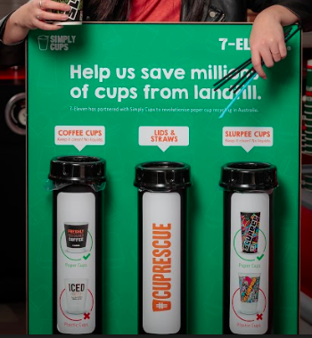 Hand in front of Simply Cups 7-Eleven cup recycling unit.