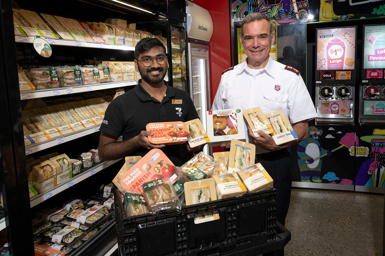 Image of store manager and member of the Salvation Army with donated food.