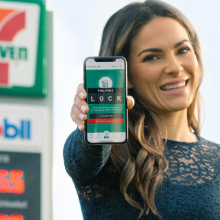 Woman holding out phone with Fuel App on display.