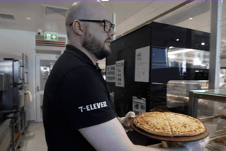 7-Eleven team member with a fresh pizza