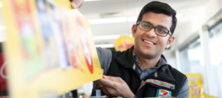 7-Eleven employee adjusting promotional material.